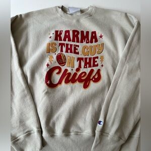 Karma is the guy on the Chiefs Champion crewneck, Travis Kelce and Taylor swift